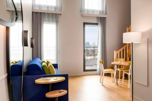 a childs room with a blue couch and a table at Aparthotel Adagio access Colombes La Défense in Colombes
