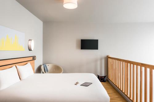 a bedroom with a bed and a tv on the wall at Aparthotel Adagio access Colombes La Défense in Colombes