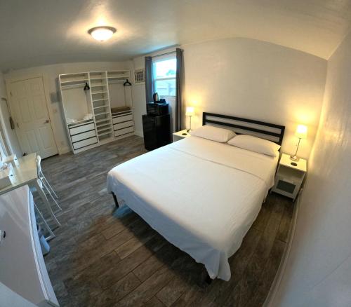 una camera con un grande letto bianco e due lampade di Nancy Vacation Homes a Hollywood