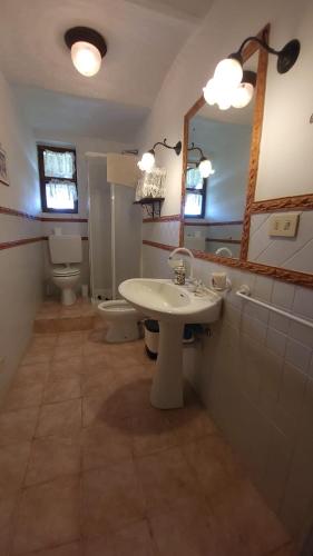 a bathroom with a sink and a toilet and a mirror at Casa Laura in Madonna della Scala