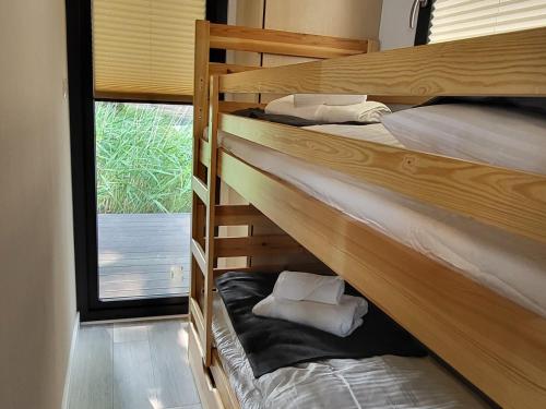 two bunk beds in a room with a window at Houseboat SeeSea Mazury - Domek na wodzie Bogaczewo k Giżycka in Bogaczewo