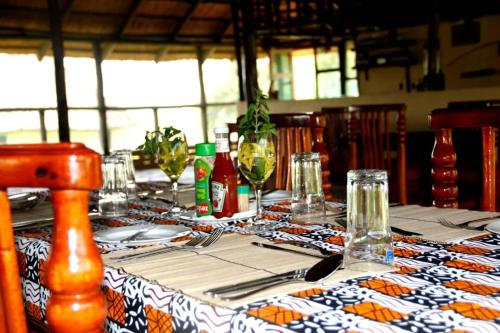 a table with a table cloth with wine glasses on it at Bar Lyec Safari Lodge in Pakwach East
