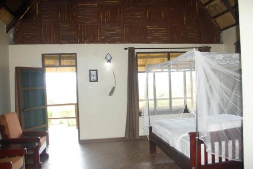 a bedroom with a bed with a canopy at Bar Lyec Safari Lodge in Pakwach East