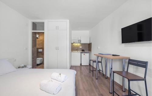 a bedroom with a bed and a table and a kitchen at 1 Bedroom Beautiful Apartment In Vodice in Vodice