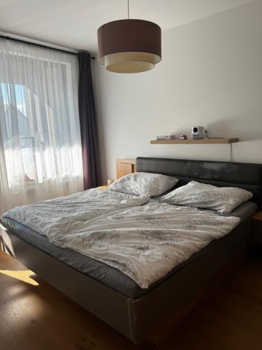 a bed in a bedroom with a large window at Apartment with Balcony and Parking, Danube & Green View in Bratislava