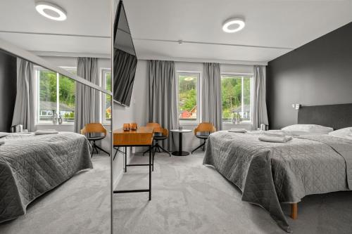 a bedroom with two beds and a mirror at Kinn Hotell Florø in Florø