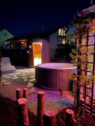 a lit up hot tub in a yard at night at Appartement Maasai Mara mit Whirlpool und Sauna in Bad Saulgau