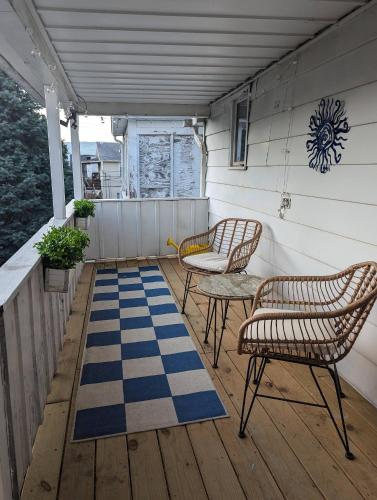 a porch with two chairs and a blue and white rug at Secluded Getaway Near Downtown, Airport, Hospitals in Pittston