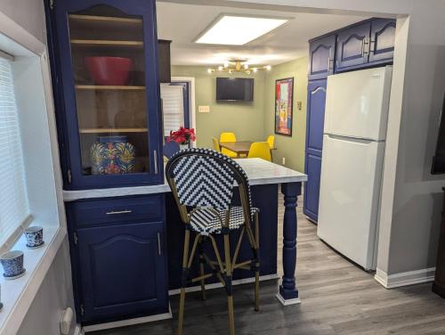 a kitchen with blue cabinets and a table and a refrigerator at Secluded Getaway Near Downtown, Airport, Hospitals in Pittston