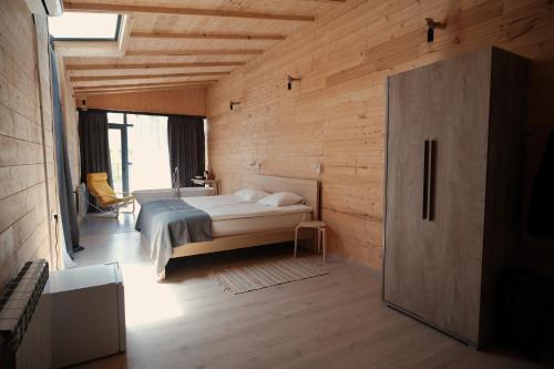 a bedroom with a bed in a room with wooden walls at Beeography guest house in Vardablur