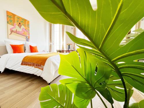 - une chambre avec une grande plante verte à côté d'un lit dans l'établissement Suite Luna - Check in h24 - proche centre ville, à Lyon
