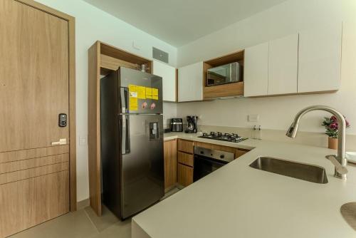 a kitchen with a black refrigerator and a sink at Baia Kristal in Cartagena de Indias