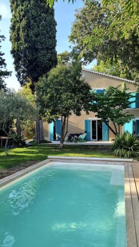 une grande piscine devant une maison dans l'établissement Le Bastidon Aix-en-provence, à Aix-en-Provence