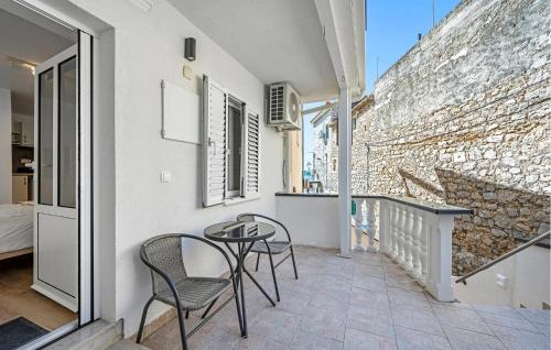 a balcony with two chairs and a table and a building at 1 Bedroom Nice Apartment In Vodice in Vodice