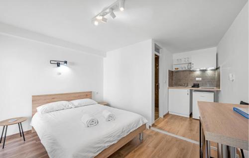 a white bedroom with a bed and a kitchen at 1 Bedroom Nice Apartment In Vodice in Vodice