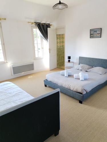 a bedroom with two beds in a room at Le Presbytère - La Trêverie in Le Torquesne