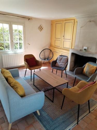 - un salon avec des canapés, des chaises et une cheminée dans l'établissement Le Presbytère - La Trêverie, à Le Torquesne