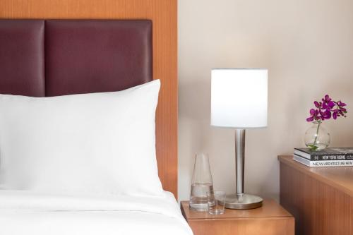 a bed with a white pillow and a lamp on a night stand at Hotel 57 in New York
