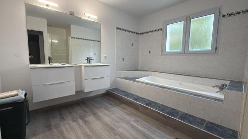 une salle de bain blanche avec une baignoire et un lavabo dans l'établissement Villa d Exception avec piscine, à Sainte-Foy