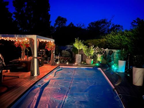 une arrière-cour avec une piscine la nuit dans l'établissement Villa d Exception avec piscine, à Sainte-Foy