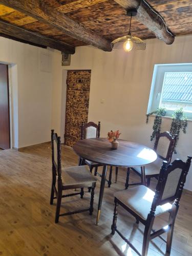 a dining room with a wooden table and chairs at Apartman Tina in Vučevica
