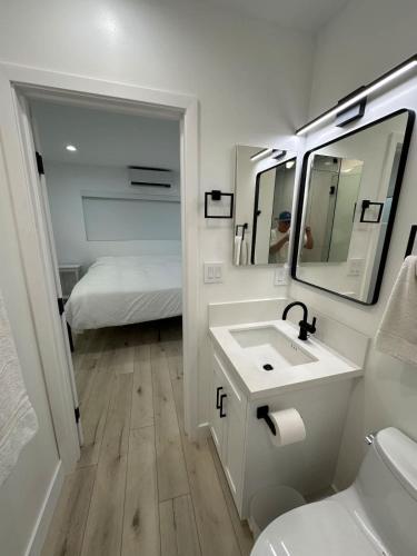 a bathroom with a sink and a mirror and a bed at Manhattan Beach Modern Panoramic Sea View in Manhattan Beach