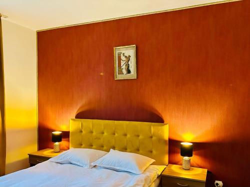 a bedroom with a bed with a red wall at Iepurasul Sinaia in Sinaia