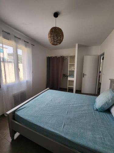 une chambre avec un grand lit et un lustre dans l'établissement VILLA avec piscine clim jolie vue Camargue, à Saint-Gilles