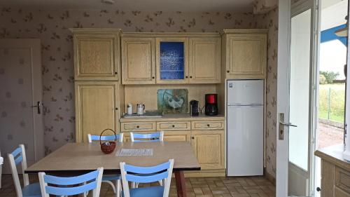 une cuisine avec une table, des chaises et un réfrigérateur dans l'établissement Chez Jeannot et Jeannette, à Allards