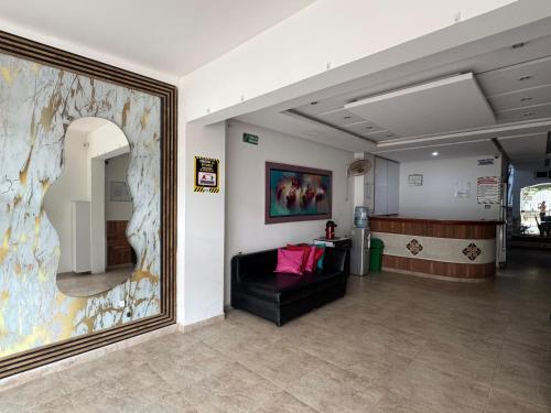 a waiting room with a couch and a large painting at Hotel Walt Sevas La Jagua in La Jagua de Ibirico
