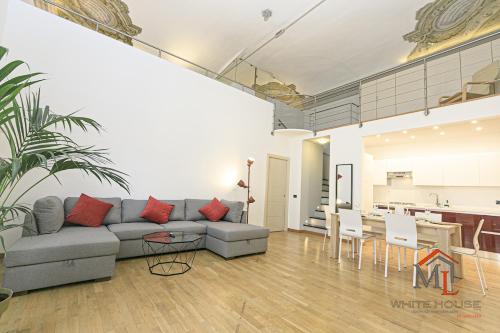 a living room with a gray couch and a kitchen at Mimosa house by ML WHITE HOUSE in Genova