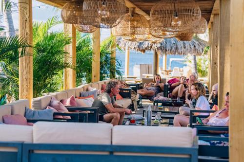 a group of people sitting on couches in a restaurant at Grand Windsock Bonaire in Kralendijk