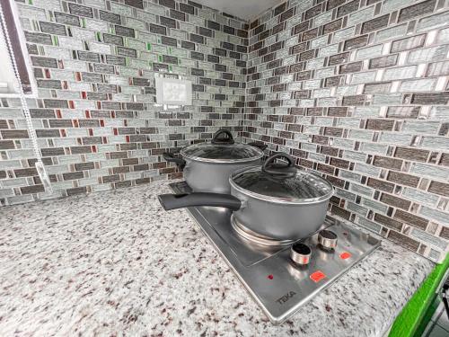 a kitchen with two pots on top of a stove at Rainbow Suites in Cozumel