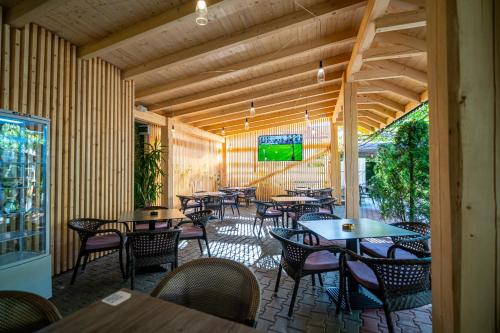 a restaurant with tables and chairs in a room at La Borsanu in Năsăud