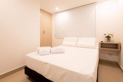 a bedroom with a bed with two white towels on it at Mishka Hotel Boutique Habitación 103 in Cartagena de Indias