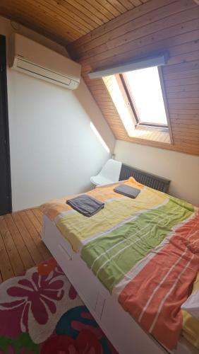a large bed in a room with a window at Ciao Bambino! in Fonyód