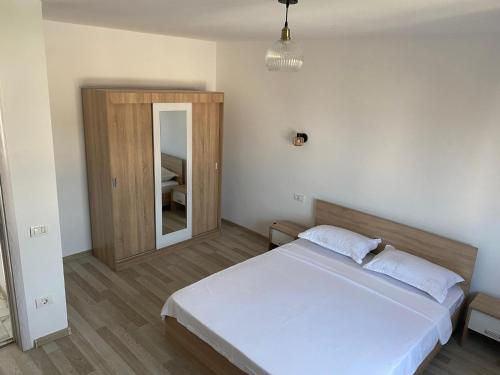 a bedroom with a white bed and a mirror at Vila Antonia in Năvodari