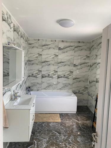 a bathroom with a tub and a sink at Vila Antonia in Năvodari