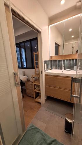 une salle de bain avec un lavabo et un miroir dans l'établissement Casimir, à Paris