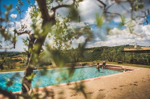 a couple of people standing in a swimming pool at Fattoria di Rignana in Greve in Chianti