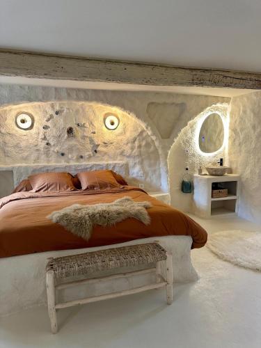 a bedroom with a large bed and a bench at CASA ANANTA Appartements bien-être aux portes du Verdon Refuge slow Life et sensoriel jusqu à 12 pers in La Garde