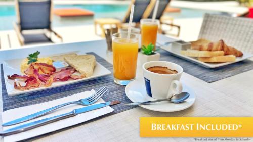 a breakfast table with a plate of food and a cup of coffee at Mullet Bay Suites - Your Luxury Stay Awaits in Cupecoy