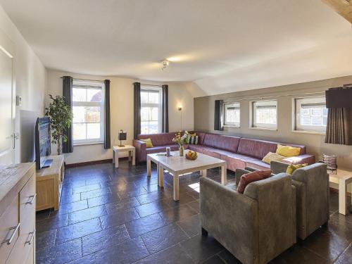 a living room with a couch and a table at Farmhouse in Limburg with Sauna & Hot Tub in Roggel