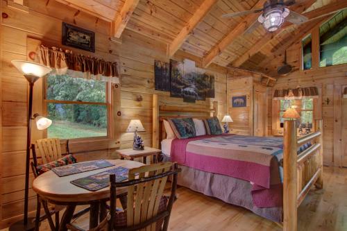 een slaapkamer in een blokhut met een bed en een tafel bij Always and Forever in Sevierville