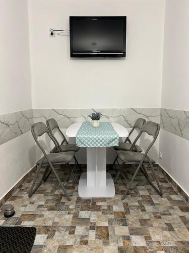 a table with chairs and a television on a wall at S-HOUSE Avrig Apartament Spațios cu Terasă Privată lângă Sibiu in Avrig