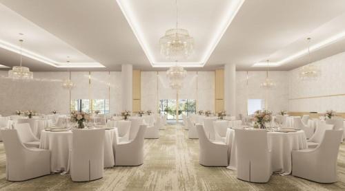 a banquet hall with white tables and white chairs at Crowne Plaza Shell Cove Marina by IHG in Shellharbour
