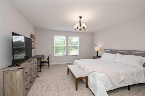 a bedroom with a bed and a dresser and a desk at Lunar Haven - Gorgeous 5 BDR in Walton