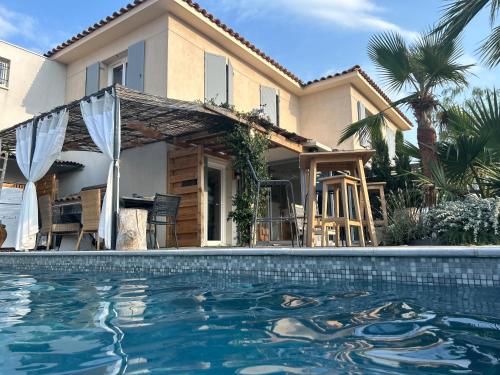 une maison avec une piscine devant une maison dans l'établissement Roquebrune Golfs Plages, à Roquebrune-sur Argens