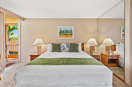 a bedroom with a large bed and a balcony at Maui Kaanapali Villas A414 in Lahaina