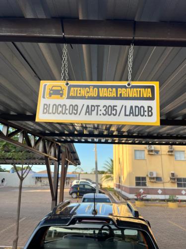 a yellow sign hanging over a parking lot at Ar nos 2 quartos e sala in Imperatriz